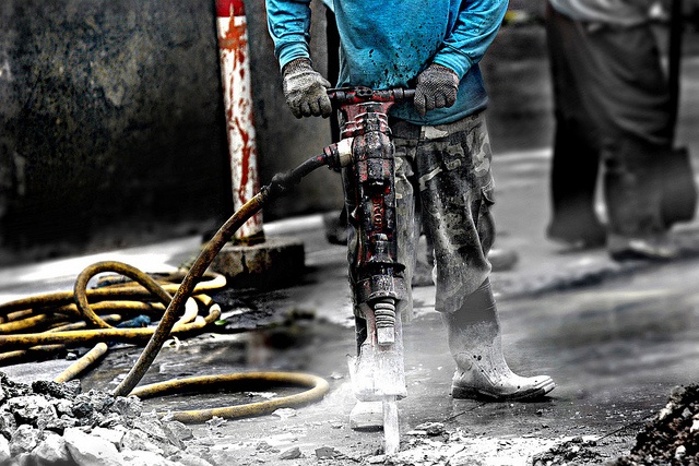 A worker uses a jackhammer during construction 